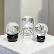 Clear quartz crystal spheres on wooden and glass stands for spiritual healing and energy work