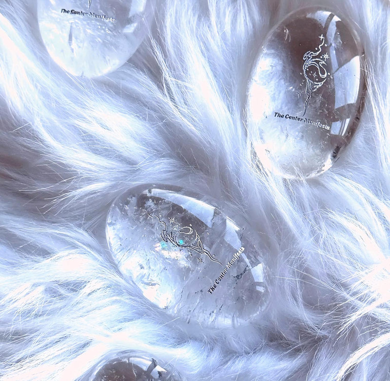 Clear quartz crystal eggs with etched designs, nestled in white fur for spiritual healing and chakra balance.