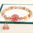 Strawberry quartz paw print bracelet with gold accents and dangling beads, ideal for healing and spiritual jewelry lovers.