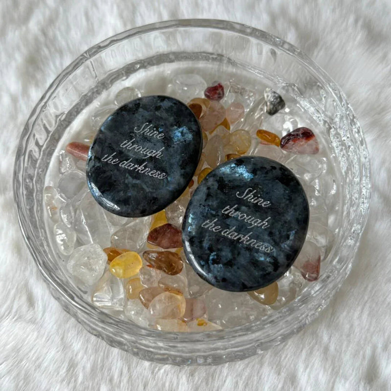 Engraved healing crystals with 'Shine through the darkness' in glass bowl, spiritual growth stones