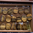 Tiger eye stones engraved with 'Solvitur ambulando' in wooden display, healing crystals for spiritual growth