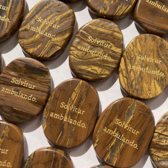 Tiger eye healing crystals engraved with 'Solvitur ambulando' for spiritual growth and anxiety relief